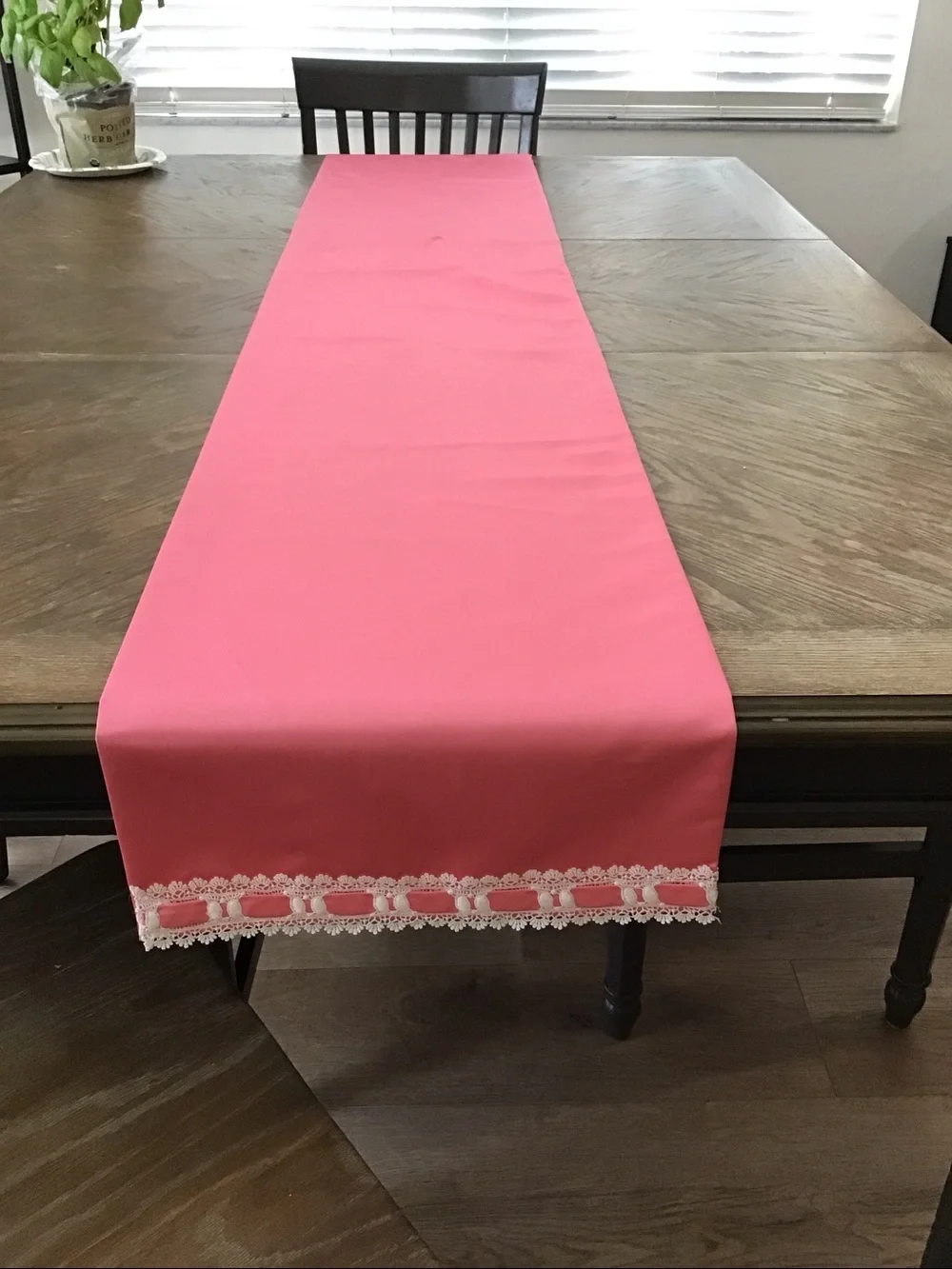 Table runner features a decorative white lace and ribbon trim
